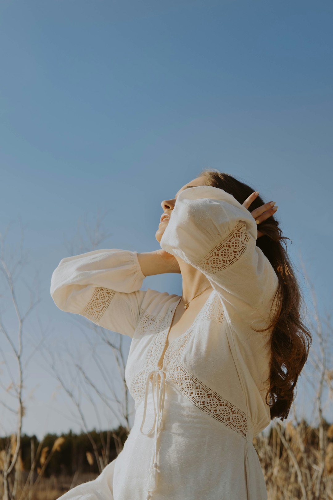 woman in white long sleeve shirt covering her face with white scarf