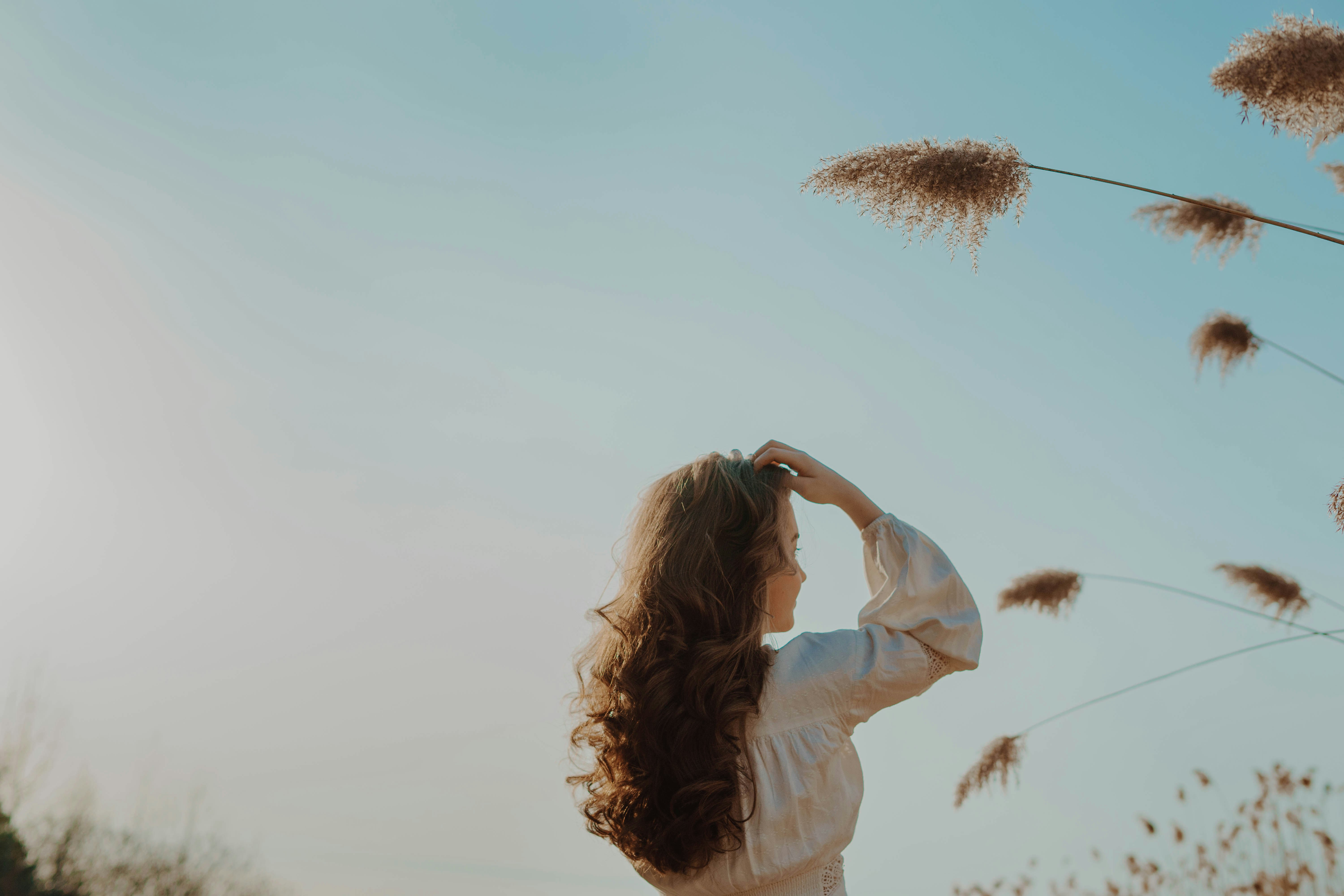 woman in white long sleeve shirt raising her hands