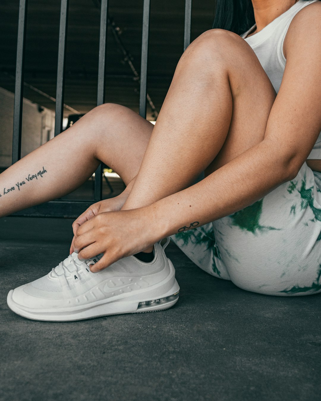 woman in white and black floral dress wearing white nike sneakers