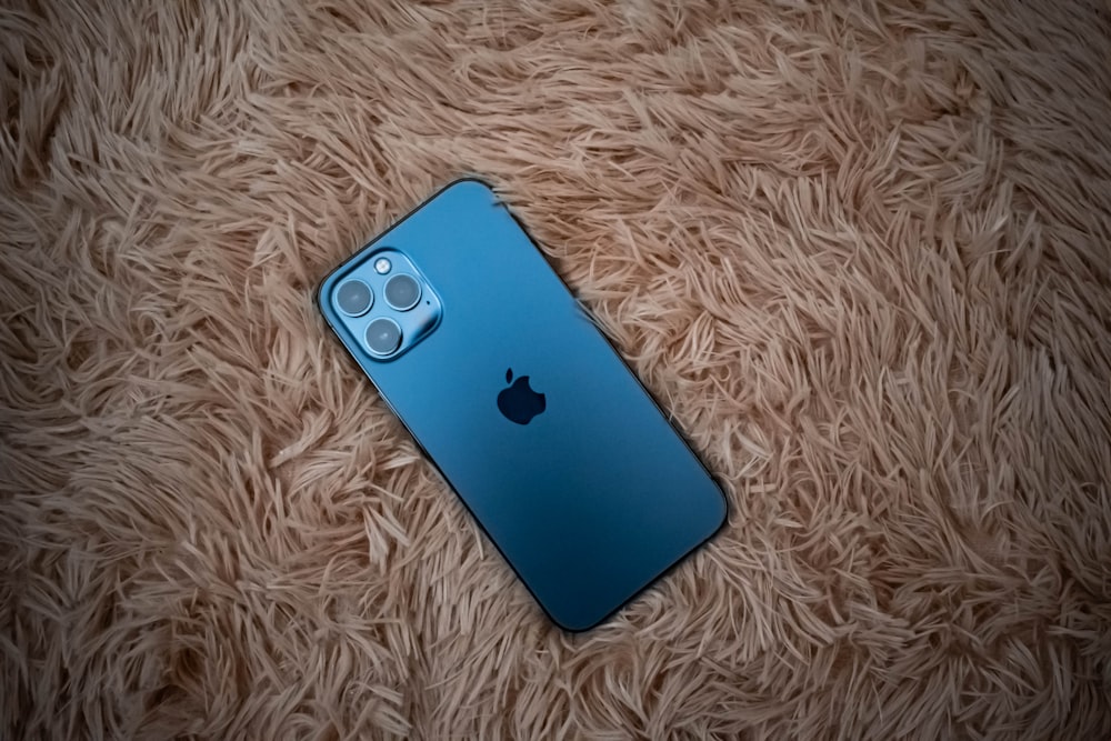 blue iphone 5 c on white textile