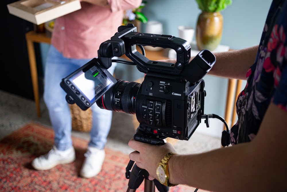 person holding black dslr camera