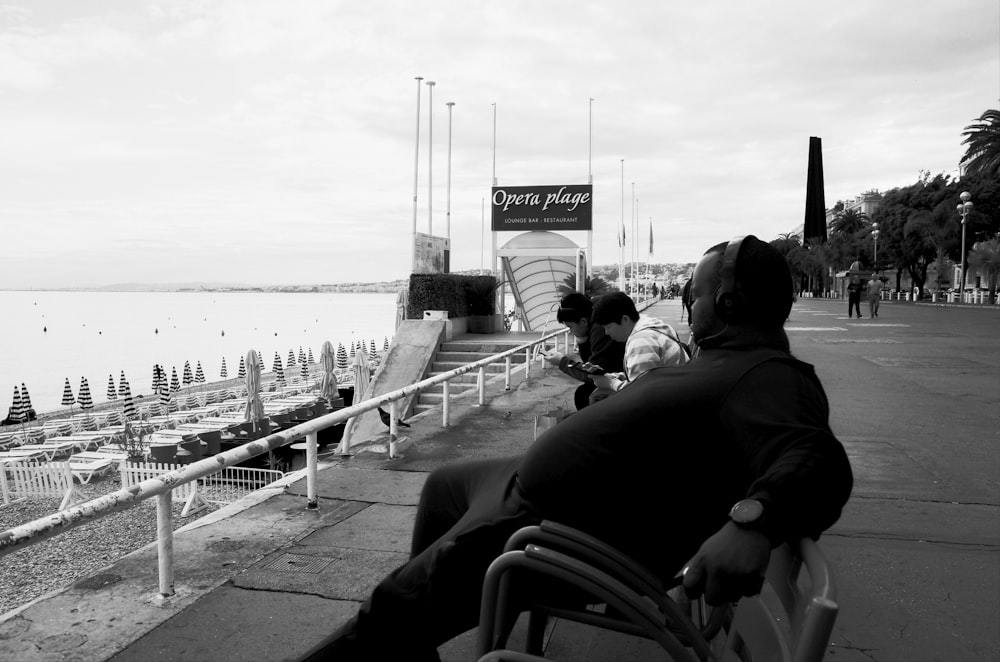 grayscale photo of people walking on the bridge