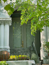 Home entrance surrounded by lush greenery in elegant planters.