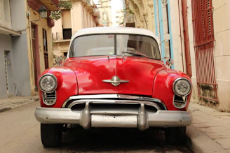 red volkswagen beetle parked on sidewalk during daytime