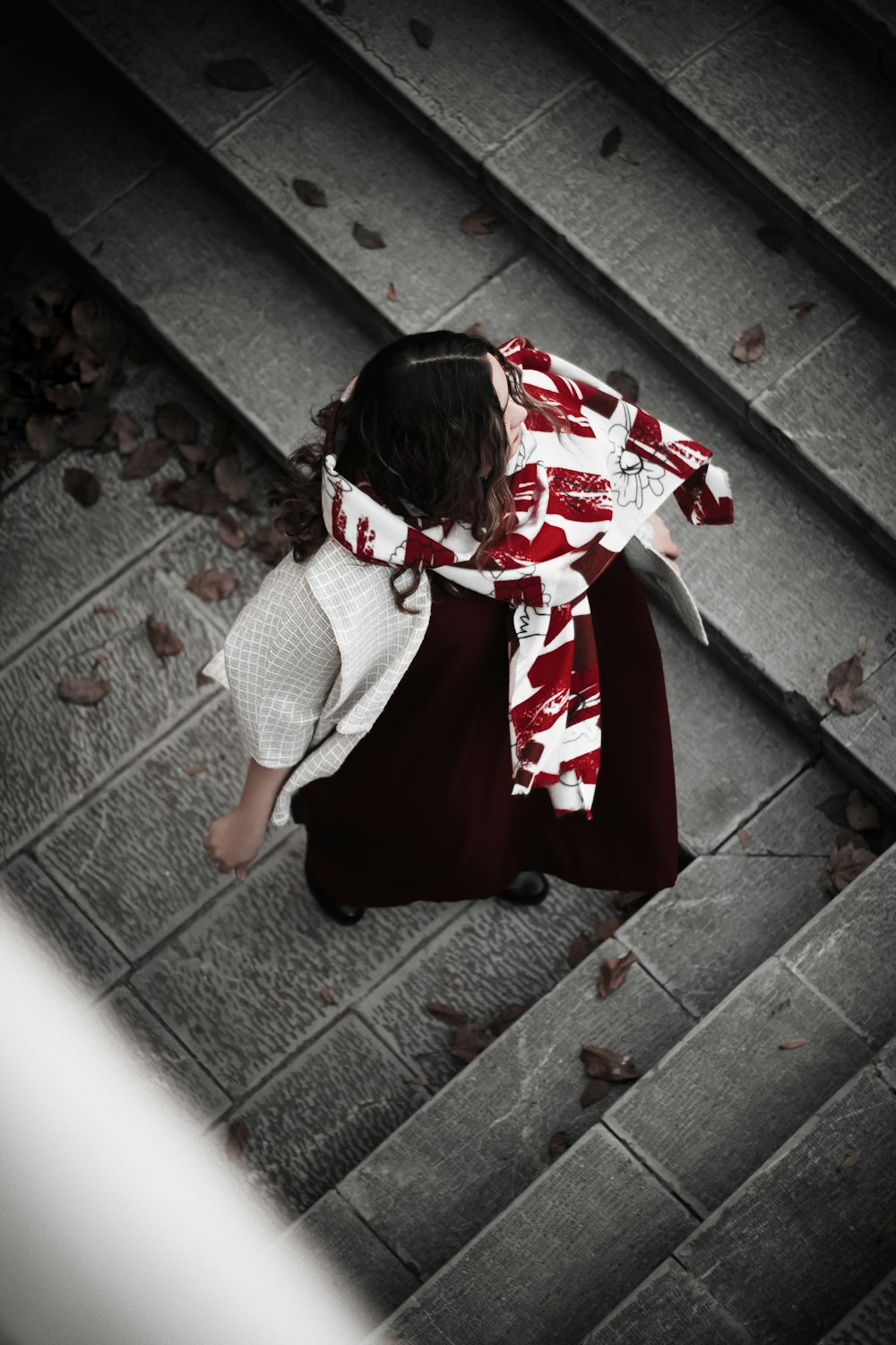 woman in white and black polka dot shirt and red skirt holding red and white textile