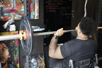man in black crew neck t-shirt holding barbell
