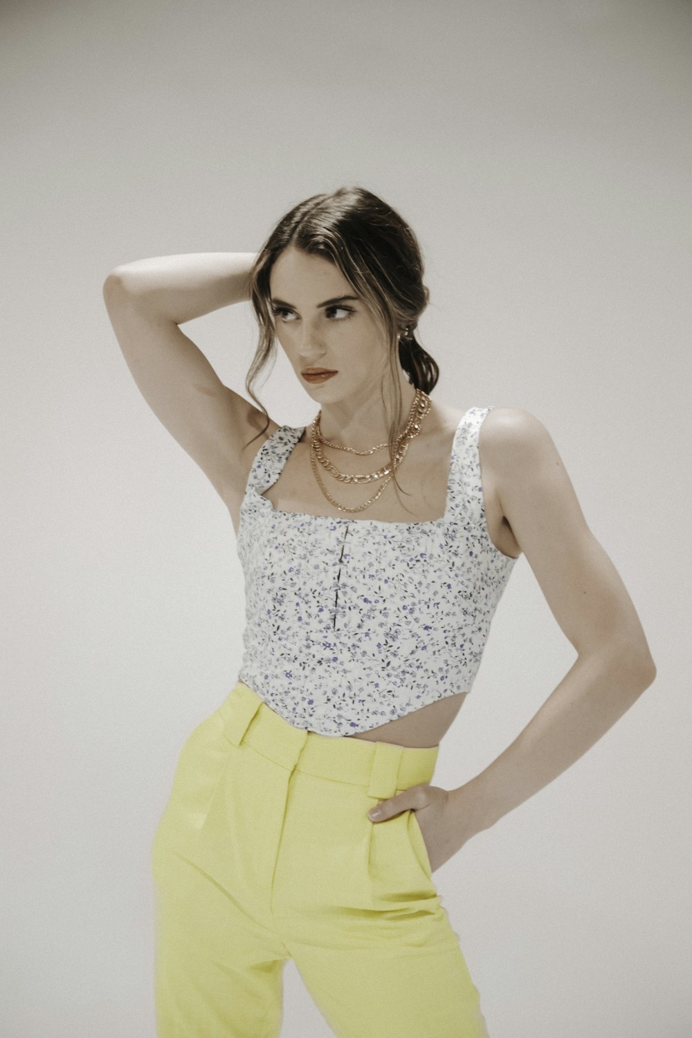 woman in white and yellow floral tank top and yellow skirt