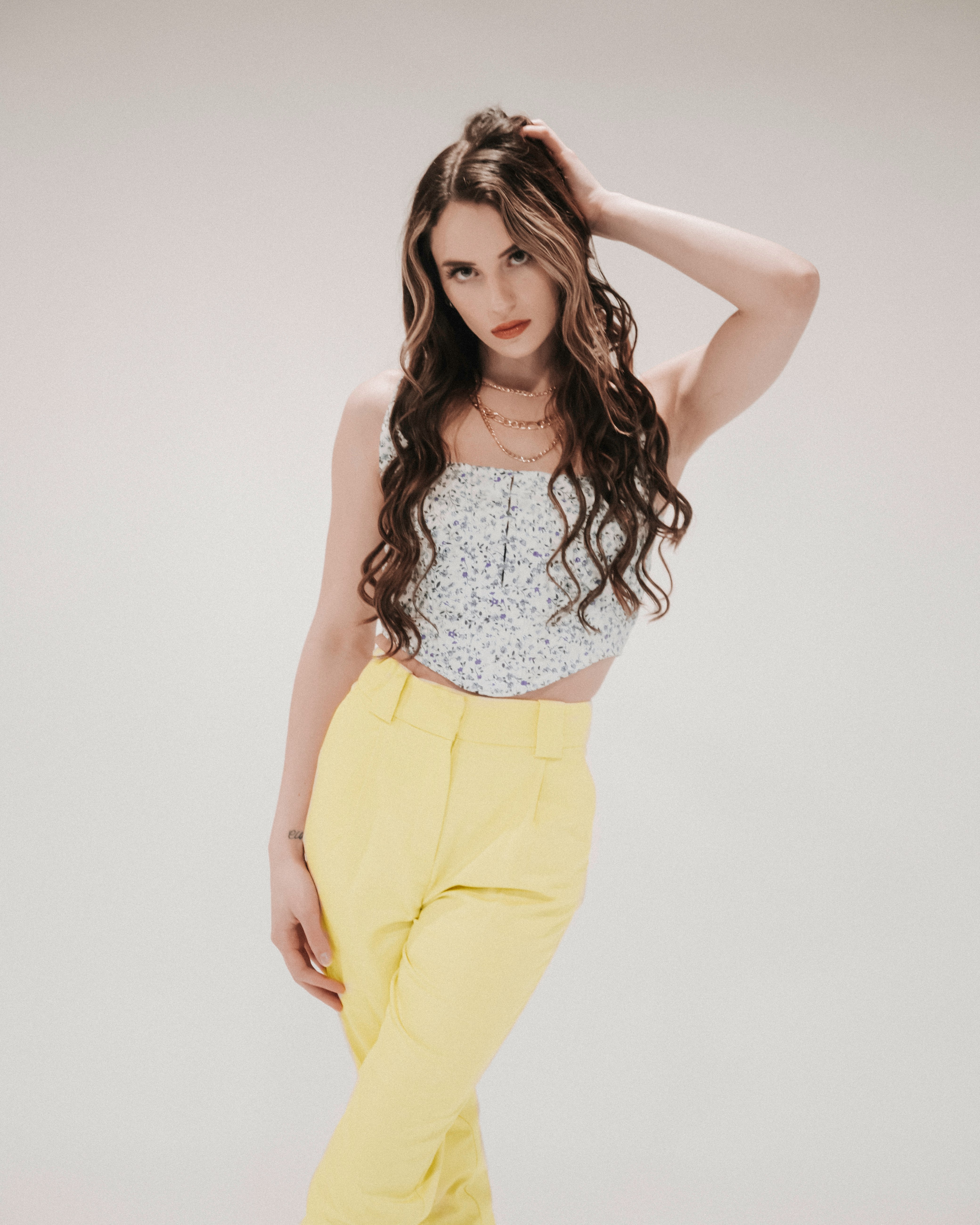 woman in white tank top and yellow pants