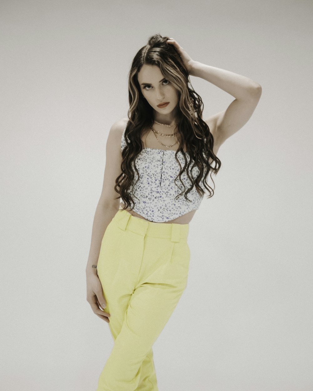 woman in white tank top and yellow pants