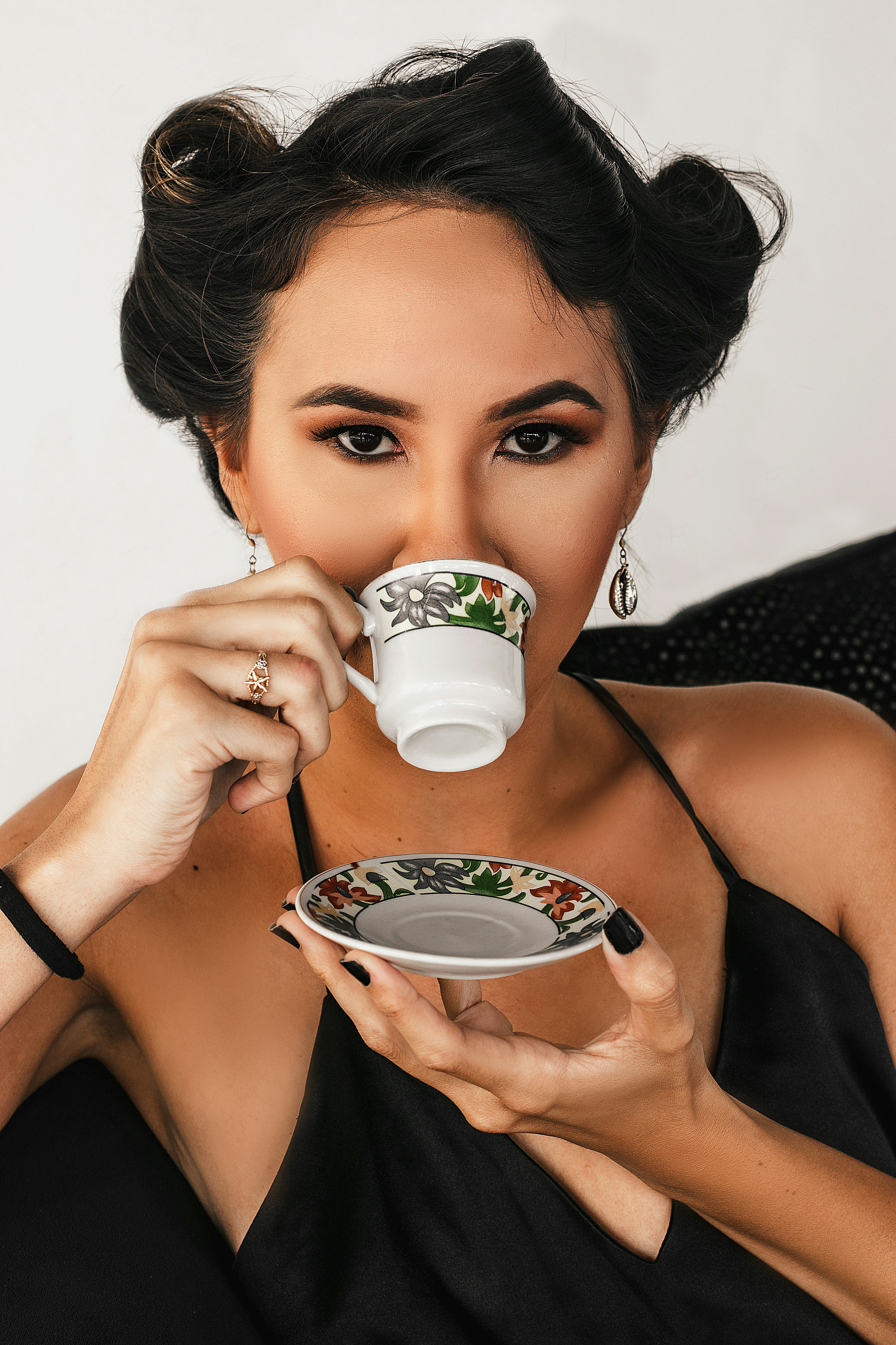 woman in black tank top holding white ceramic mug
