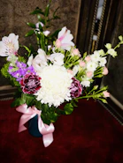 A vibrant bouquet of assorted flowers in a decorative vase.