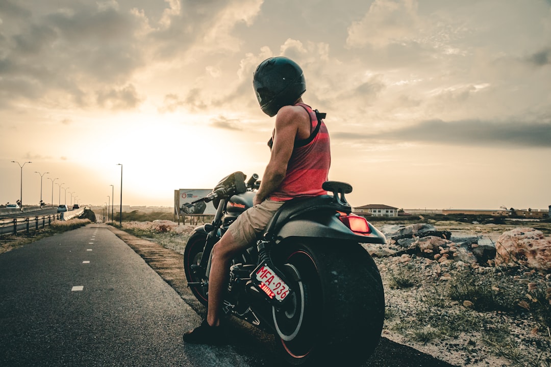 man in red shirt and black helmet riding on black motorcycle