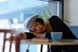woman in black long sleeve shirt lying on white wooden table
