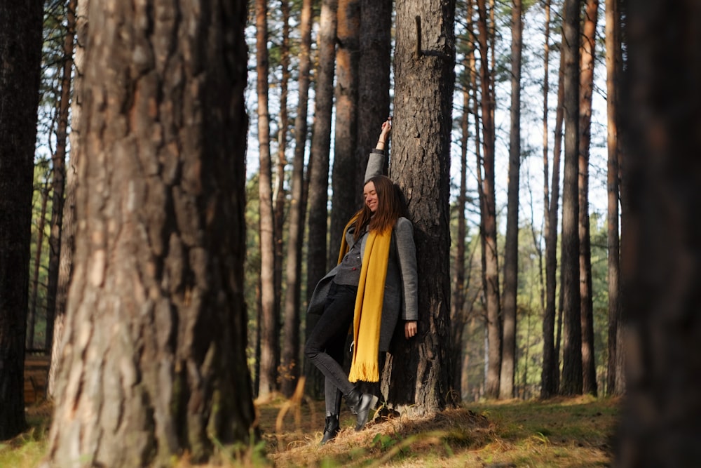 woman in black jacket standing near brown tree during daytime