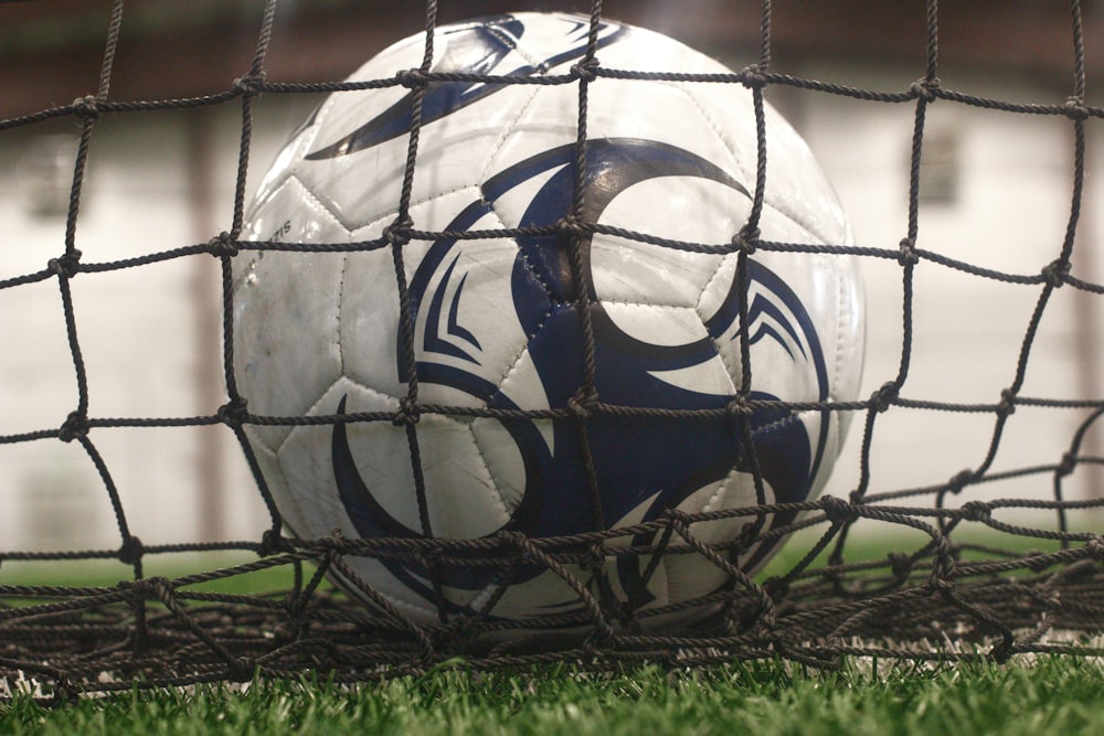 white and blue soccer ball on green grass