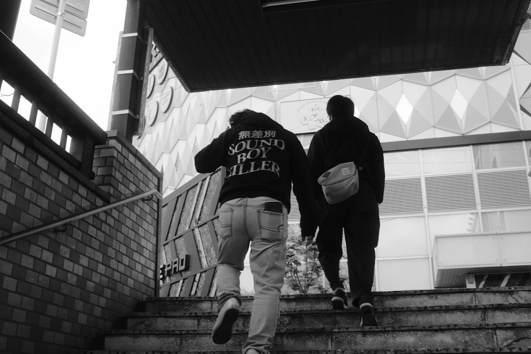 grayscale photo of man and woman standing on stairs