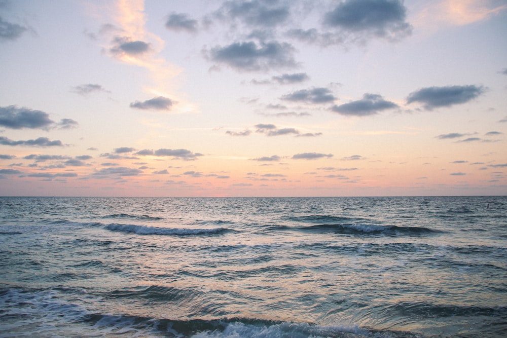 ocean waves under cloudy sky during daytime