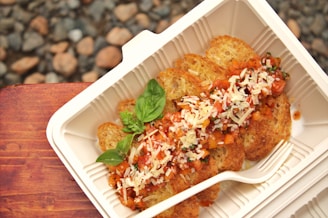 fried food with green leaf on white rectangular plate