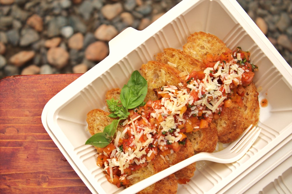 fried food with green leaf on white rectangular plate