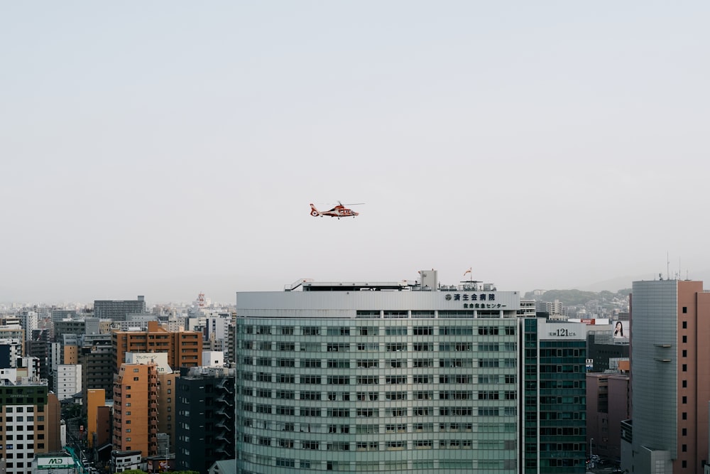 white airplane flying over city buildings during daytime