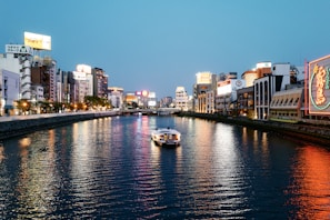 white boat on river near city buildings during daytime