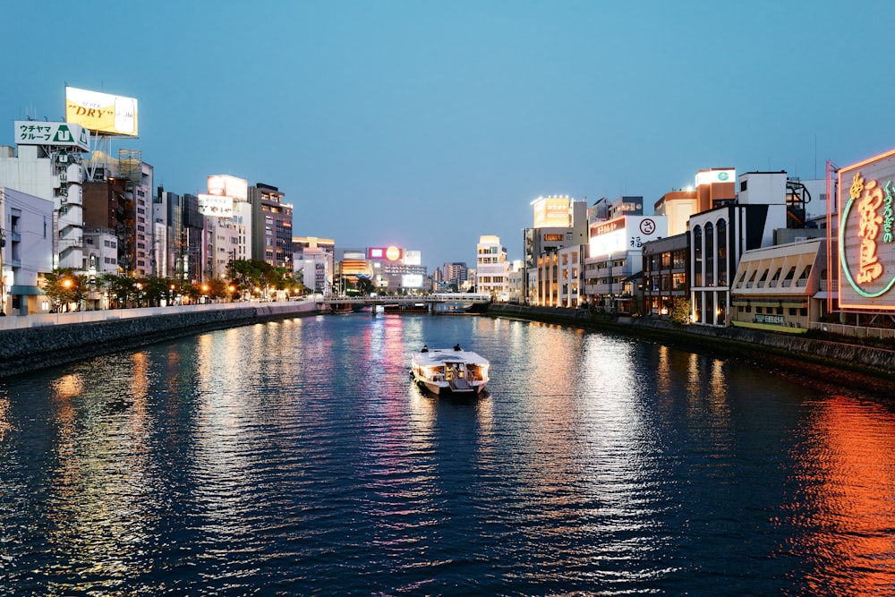 white boat on river near city buildings during daytime