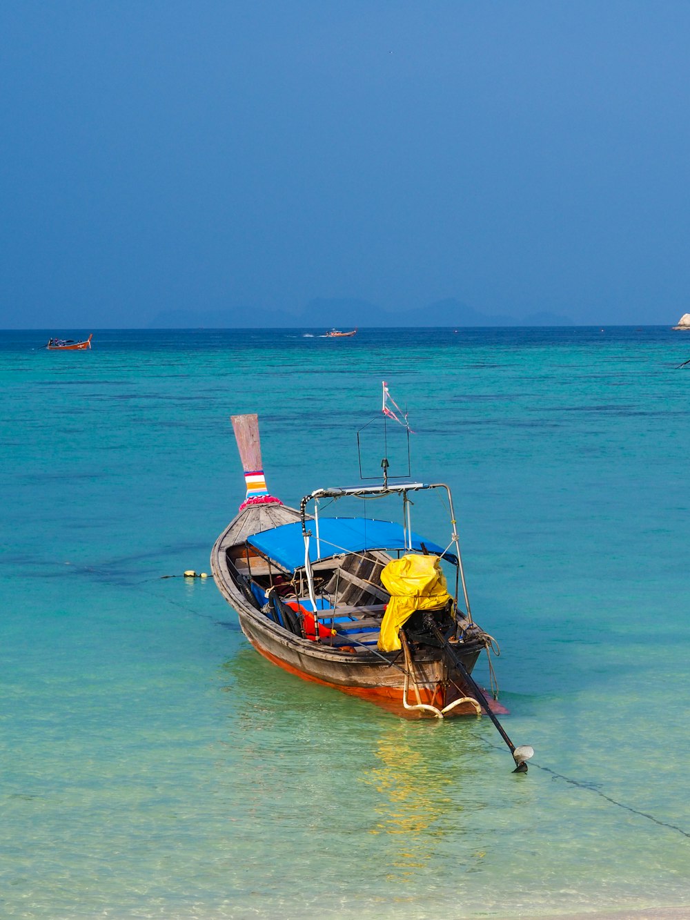 man in yellow shirt riding on red and yellow boat on sea during daytime