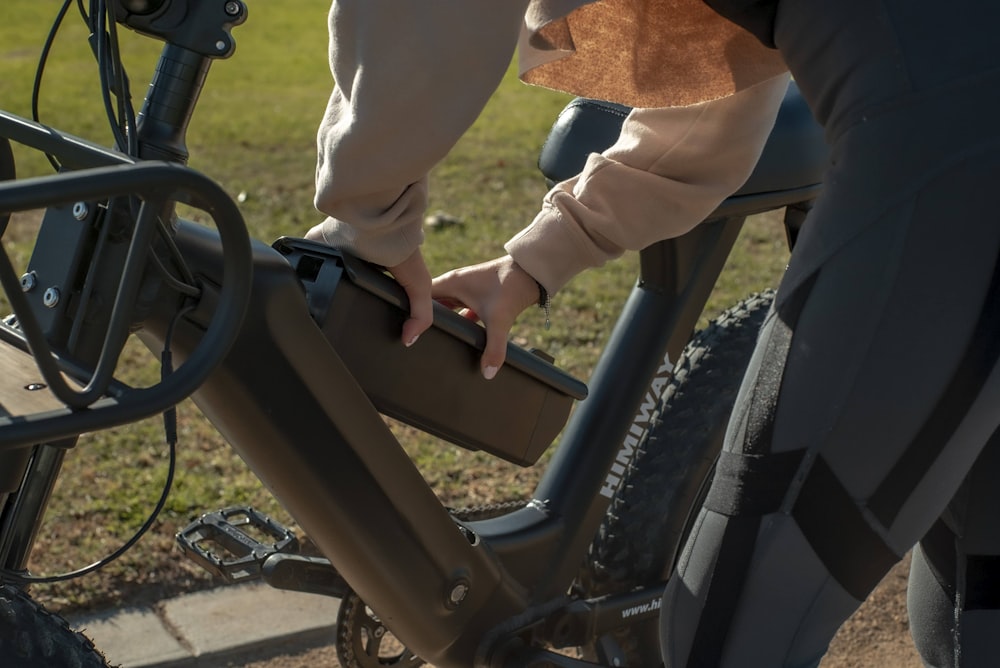 Persona con camisa blanca de manga larga montando en bicicleta negra durante el día