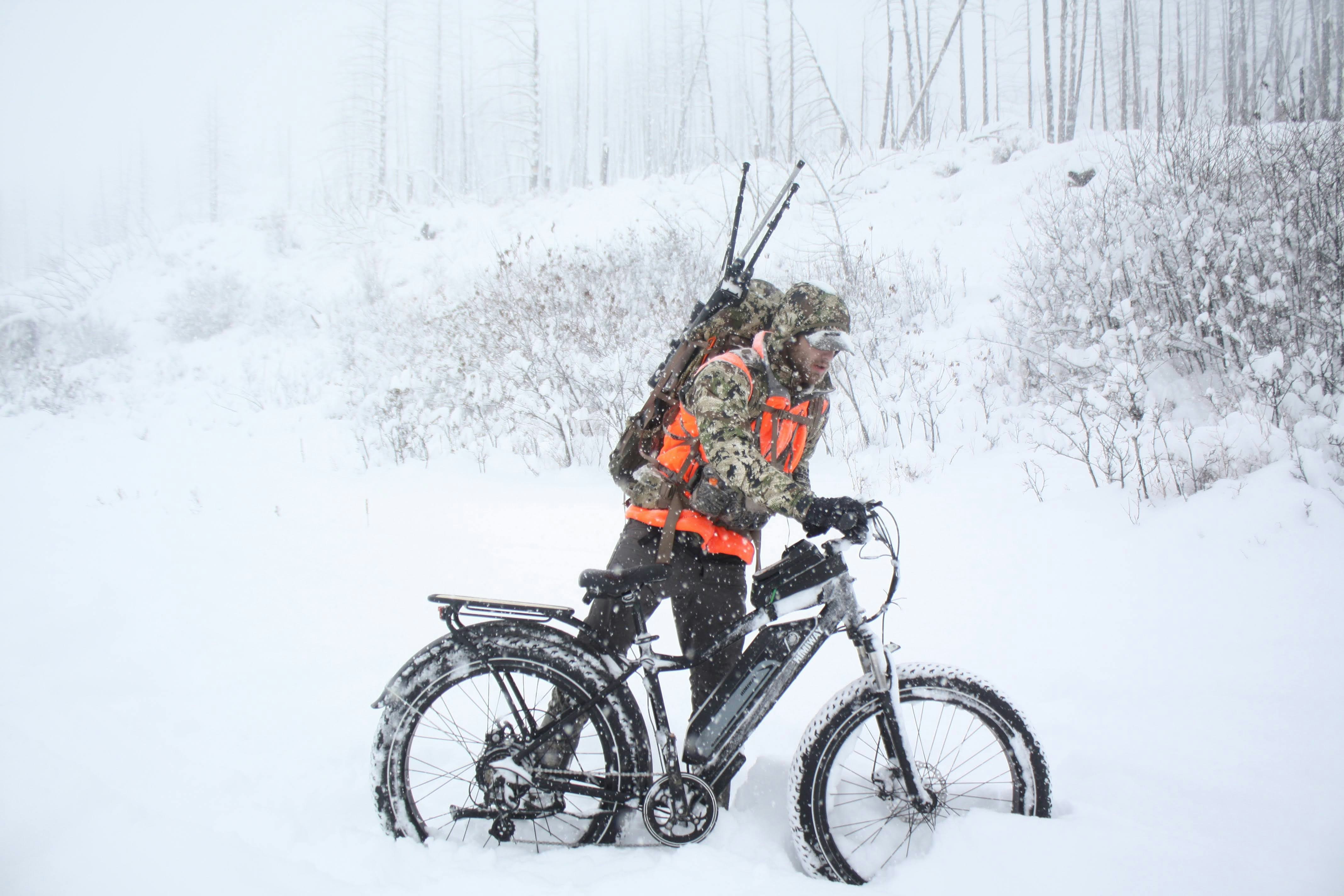 woman in black jacket riding on black mountain bike on snow covered ground during daytime