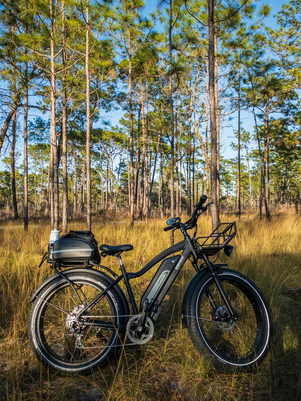 Bicicleta de montaña negra y gris en campo de hierba marrón durante el día