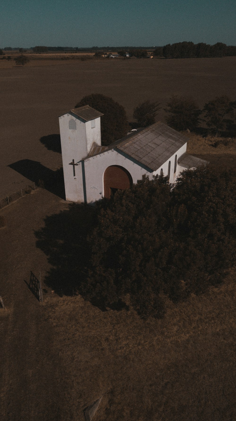 casa di cemento bianco e marrone vicino agli alberi verdi durante il giorno