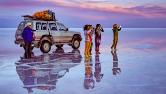 woman in black jacket and pink pants standing on white suv
