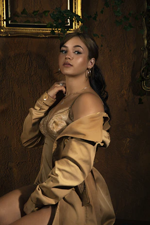 Elegant portrait of Megan Faux in a softly lit, luxurious setting with blush pink and gold accents.