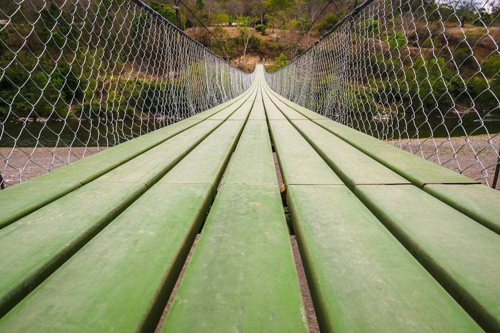 banco de madera verde cerca de la valla de metal gris