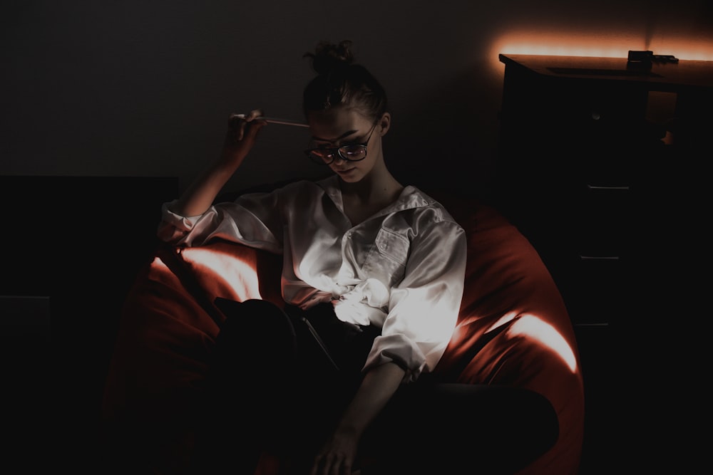 man in white button up shirt sitting on red sofa chair