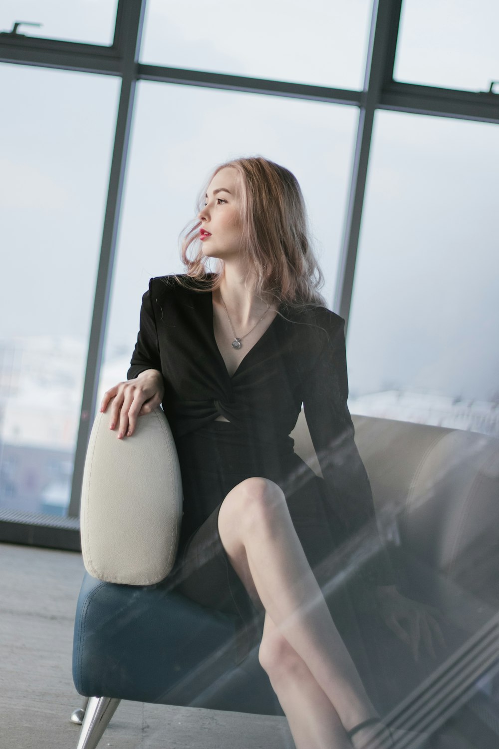 woman in black blazer sitting on white chair