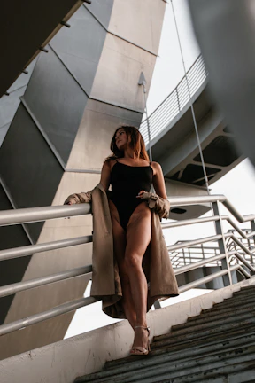 A stylish woman in elegant lingerie standing near the iconic Le Havre architecture.
