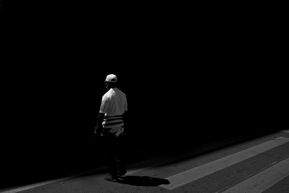 man in white dress shirt and black pants walking on road