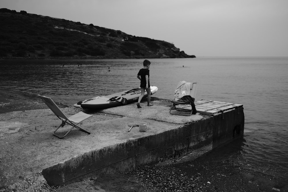 man and woman sitting on concrete dock near body of water during daytime