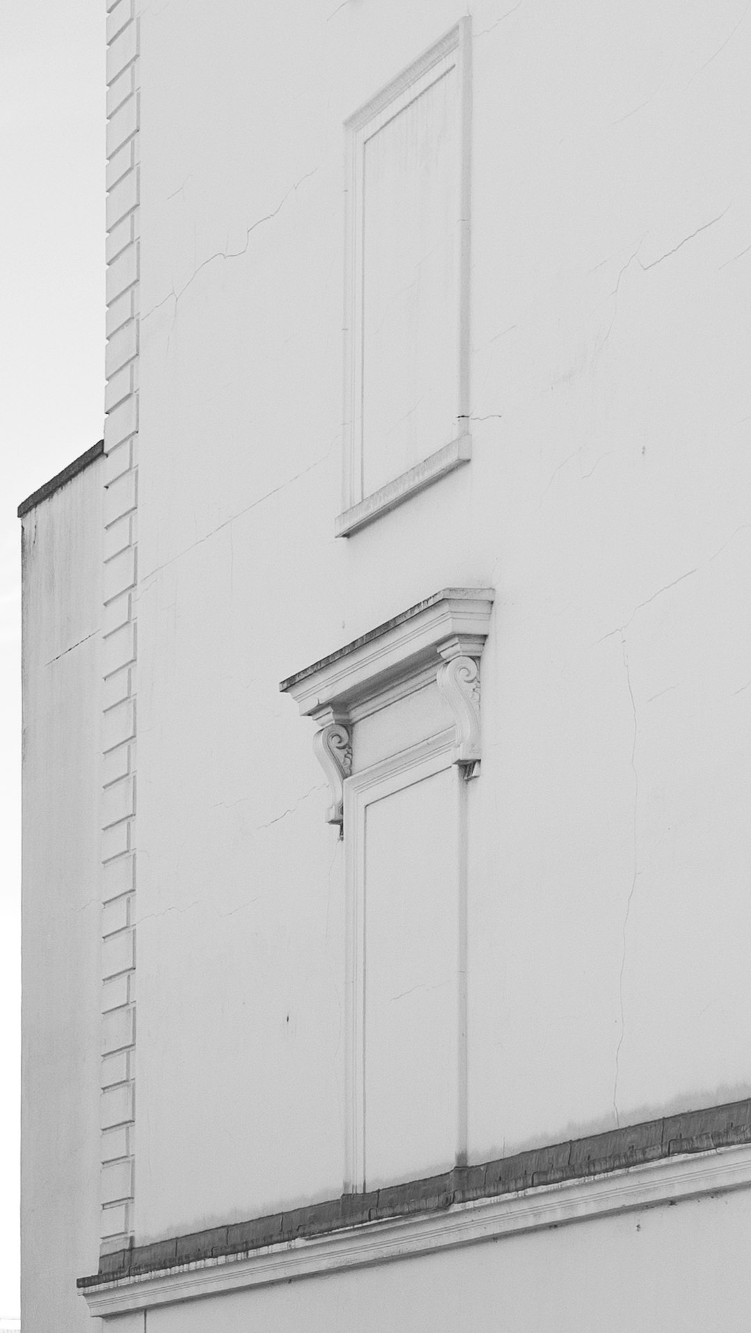 white wooden door on white concrete wall