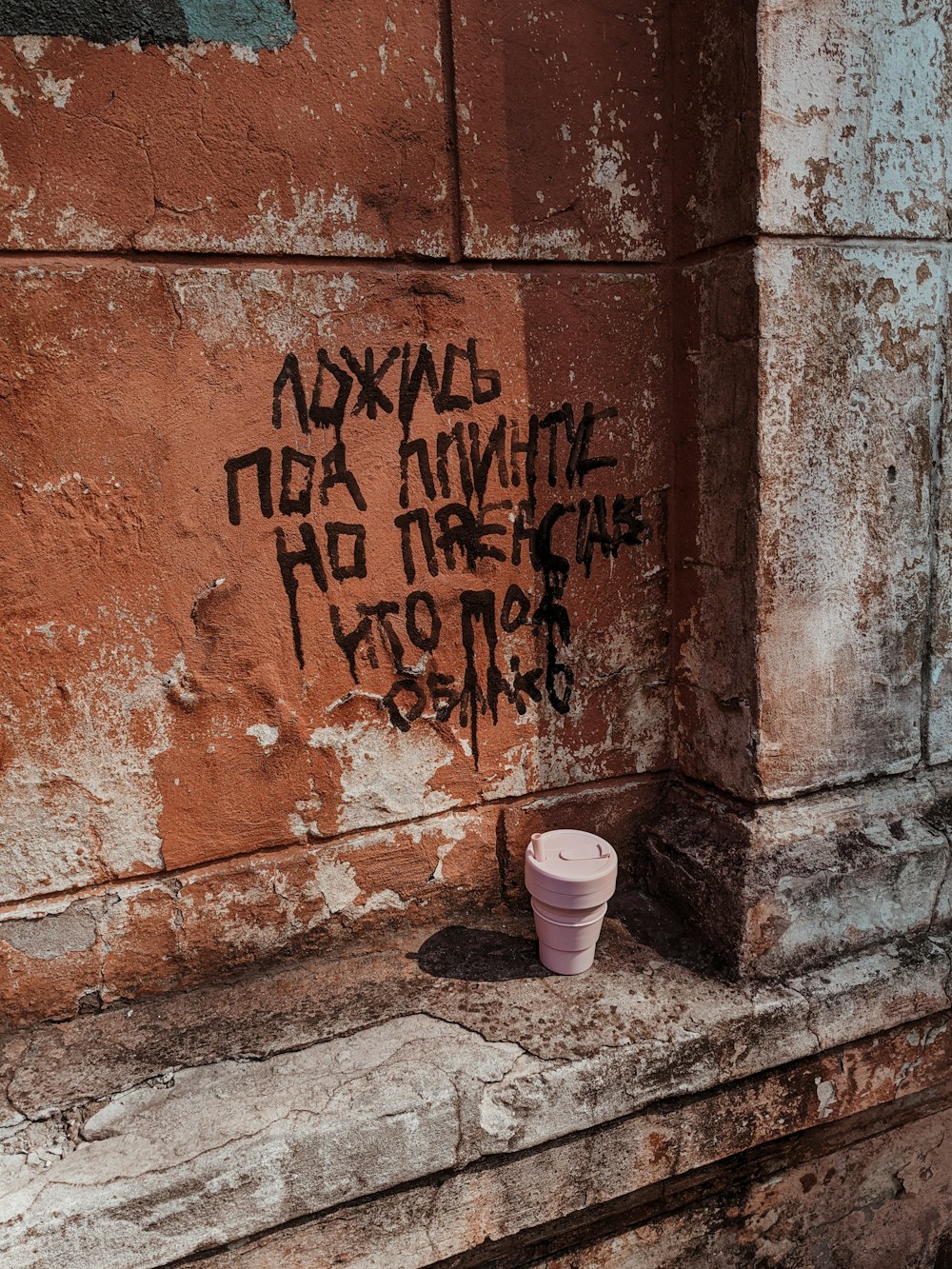 white and brown plastic cups beside brown concrete wall