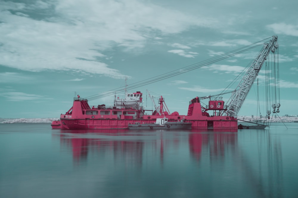 red and white boat on body of water under cloudy sky during daytime