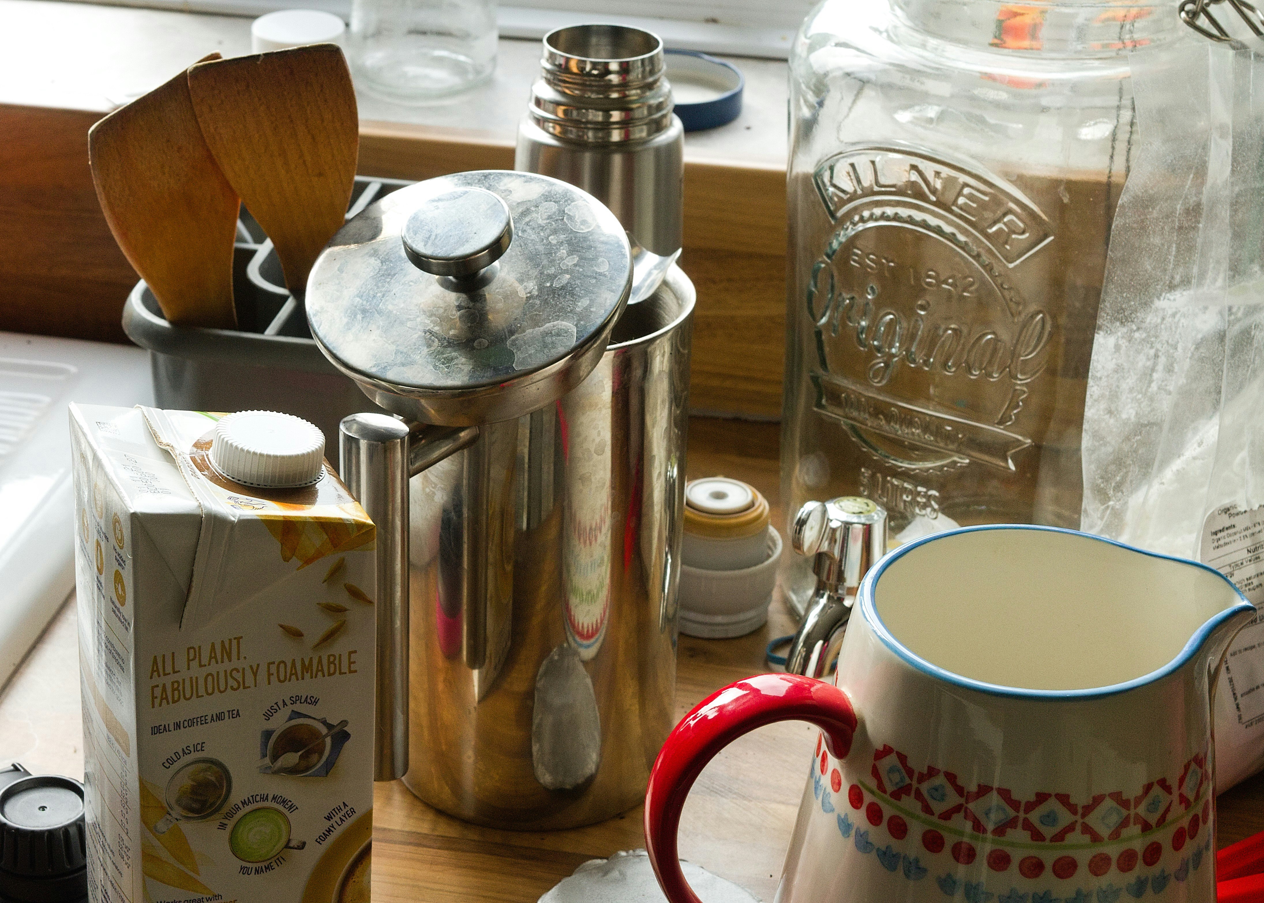 stainless steel pitcher beside white ceramic mug