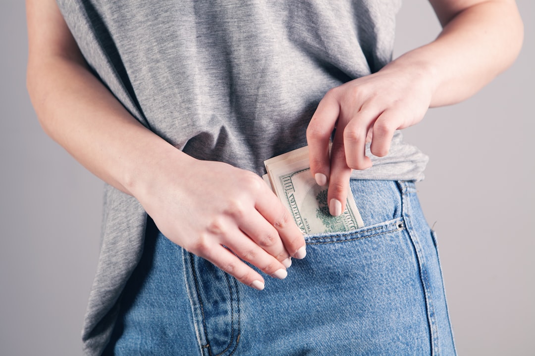 woman saving some money into her front pocket 