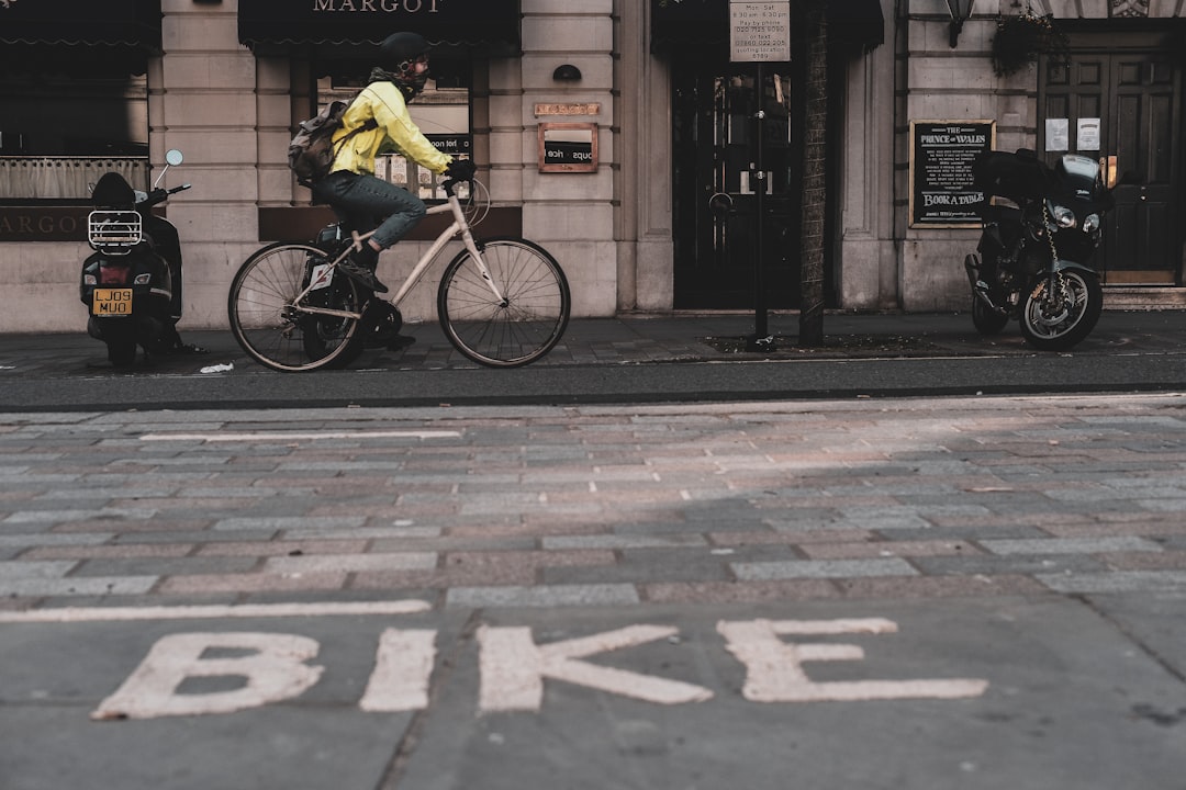 man in yellow shirt riding bicycle on sidewalk during daytime