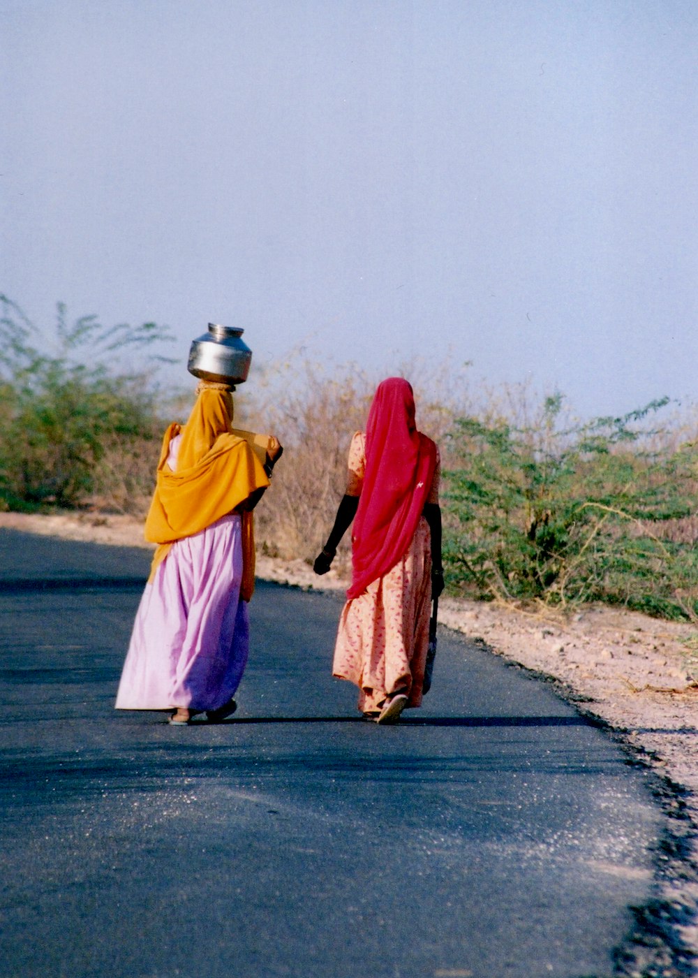 woman in red hijab and yellow dress walking on road during daytime