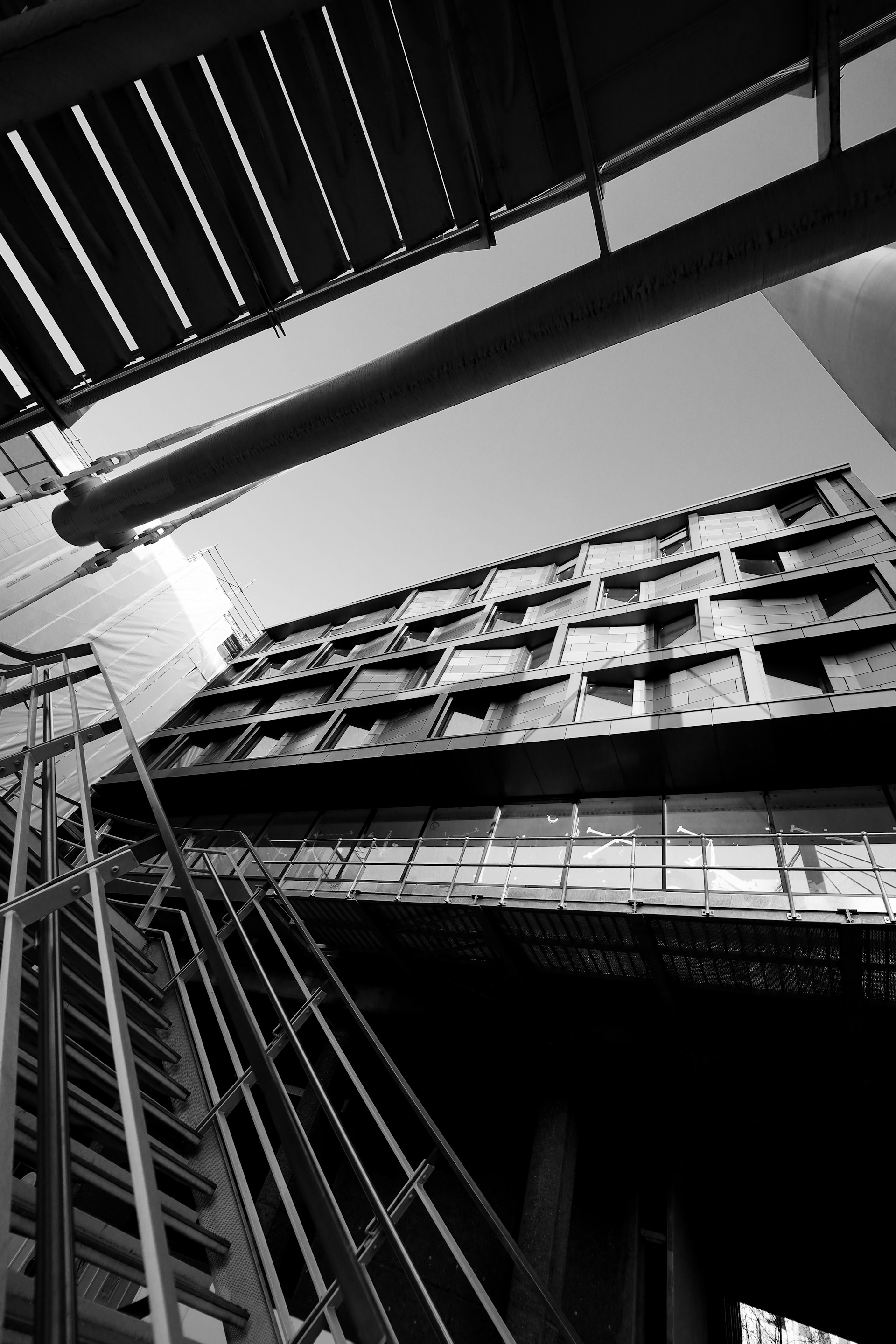 An elegant architectural shot emphasizing clean lines and contrast between deep black shadows and sharp yellow accents.