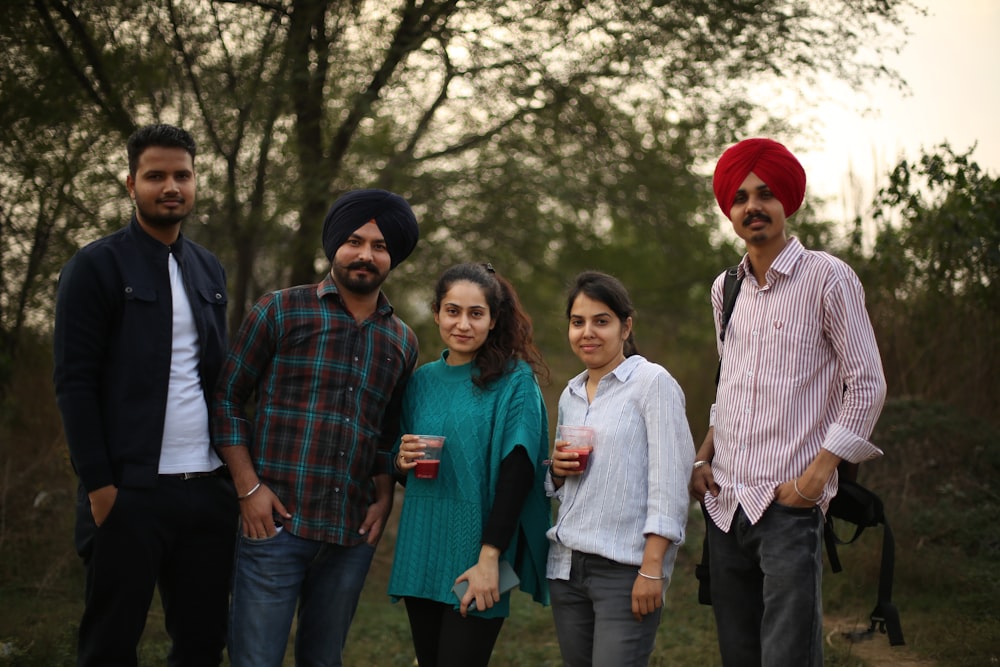 group of people standing near green trees during daytime