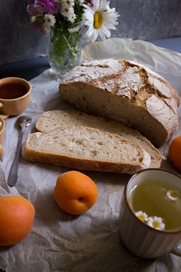 bread on white ceramic plate beside orange fruit