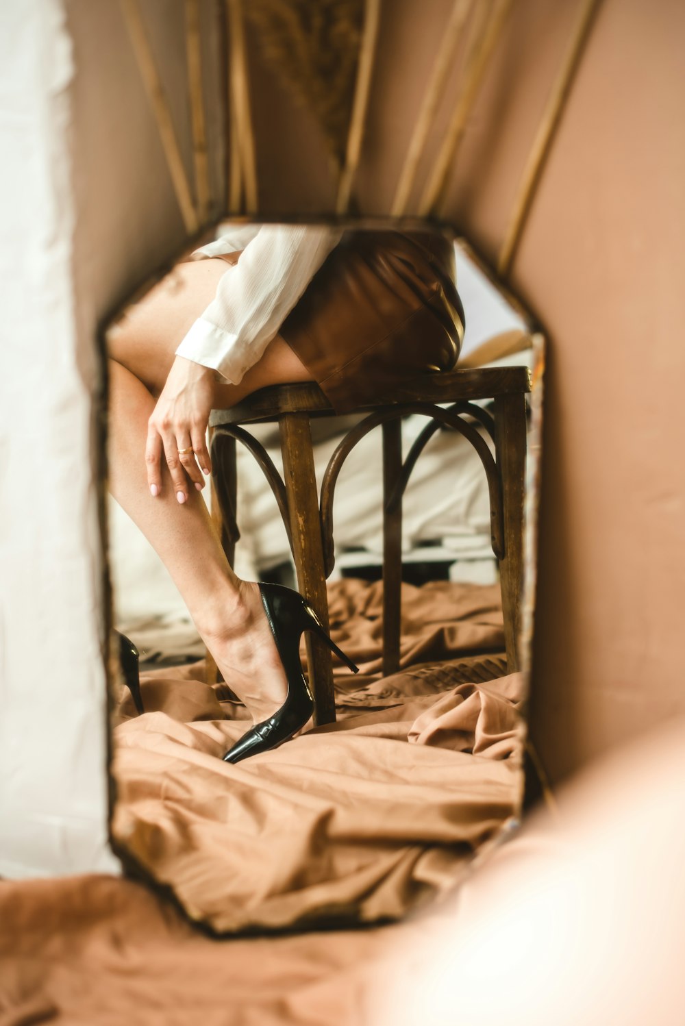 Mujer en vestido blanco sentada en silla de madera marrón